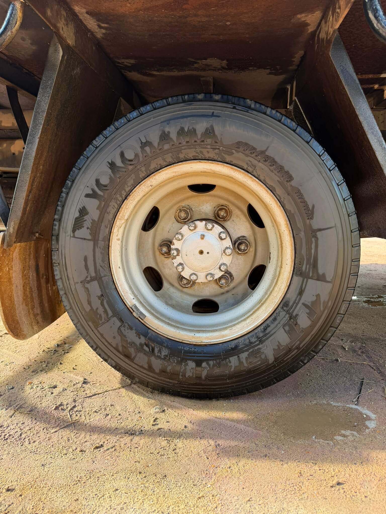 Truck wheel rim and hub with chipped, stained paint before blasting