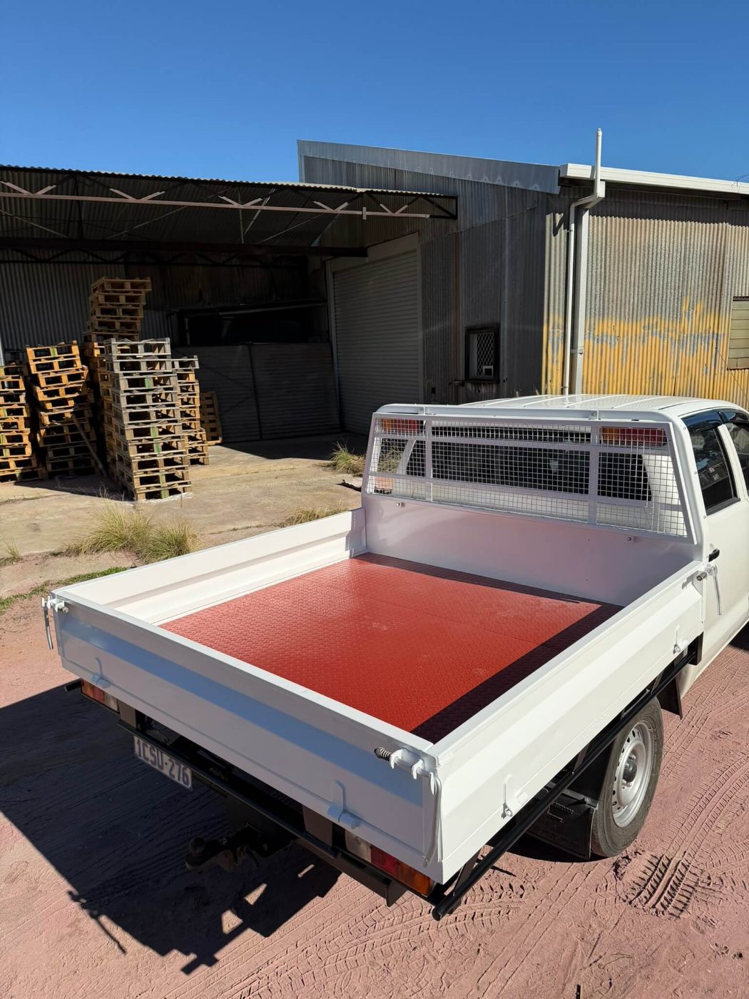 The same ute tray and cab guard finished in white with the checker-plate floor recoated red