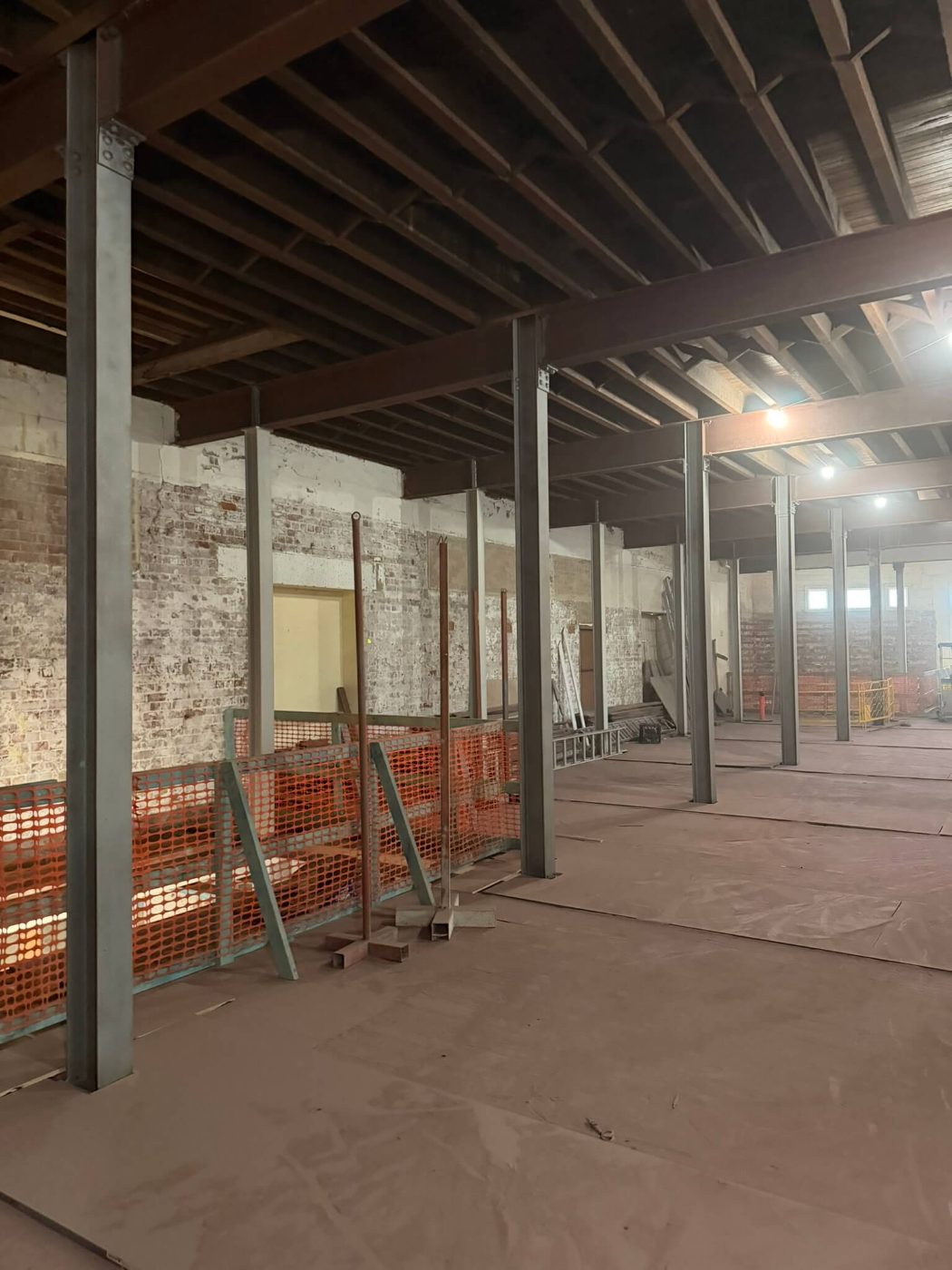 The same columns and beams blasted back to clean steel with the brickwork and floor protected