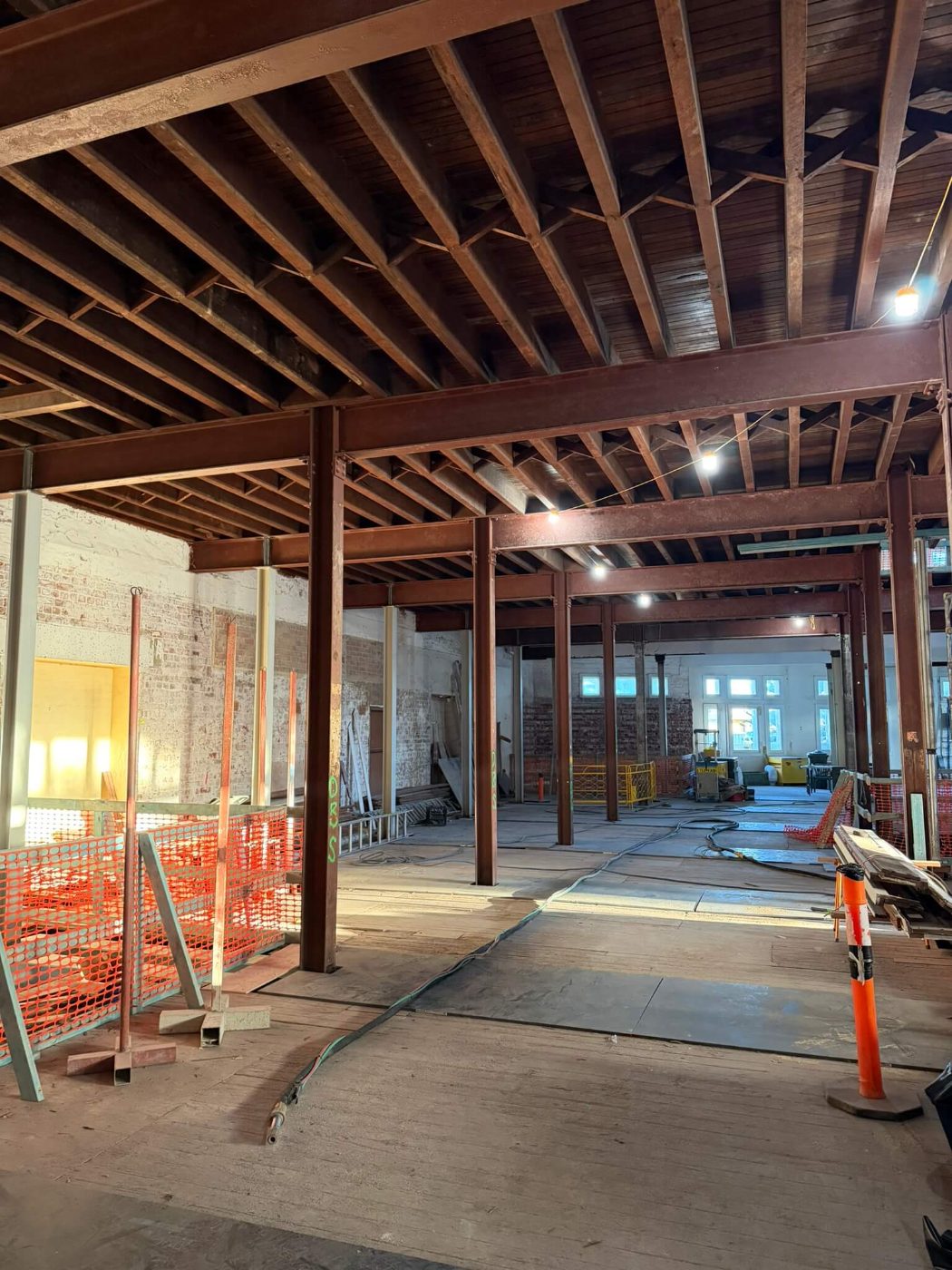 Structural steel columns and beams coated in rust inside a heritage brick building before blasting
