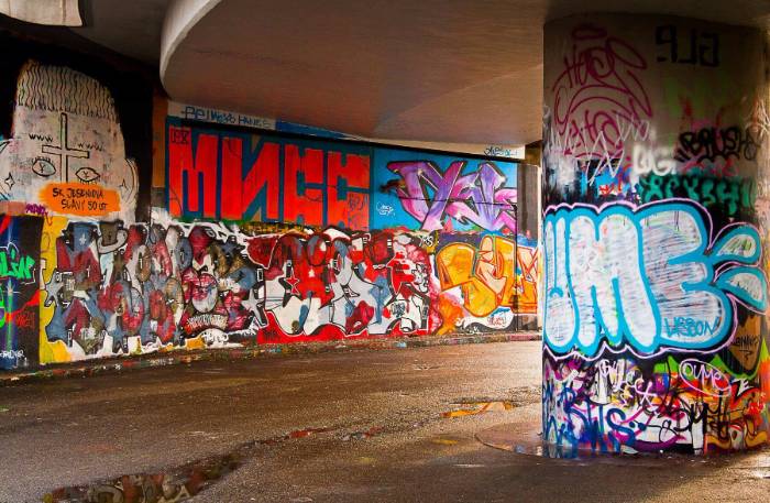 Painted tags stripped from a rendered wall with wet abrasive blasting