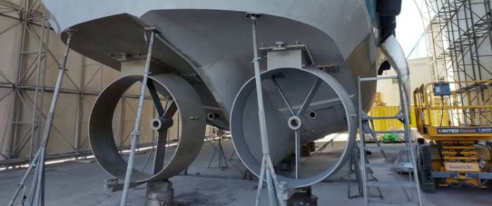 Ship hull abrasive blasting alongside a portable blast pot