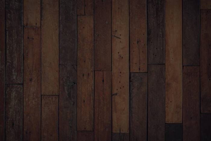 Jarrah beam half stripped of dark stain showing clean timber grain underneath