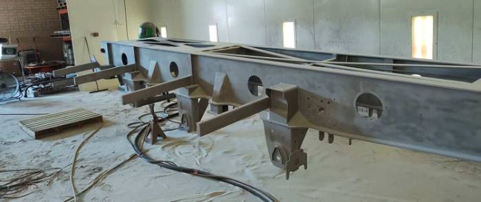 Truck cab panel being blasted to remove layered paint without warping the steel